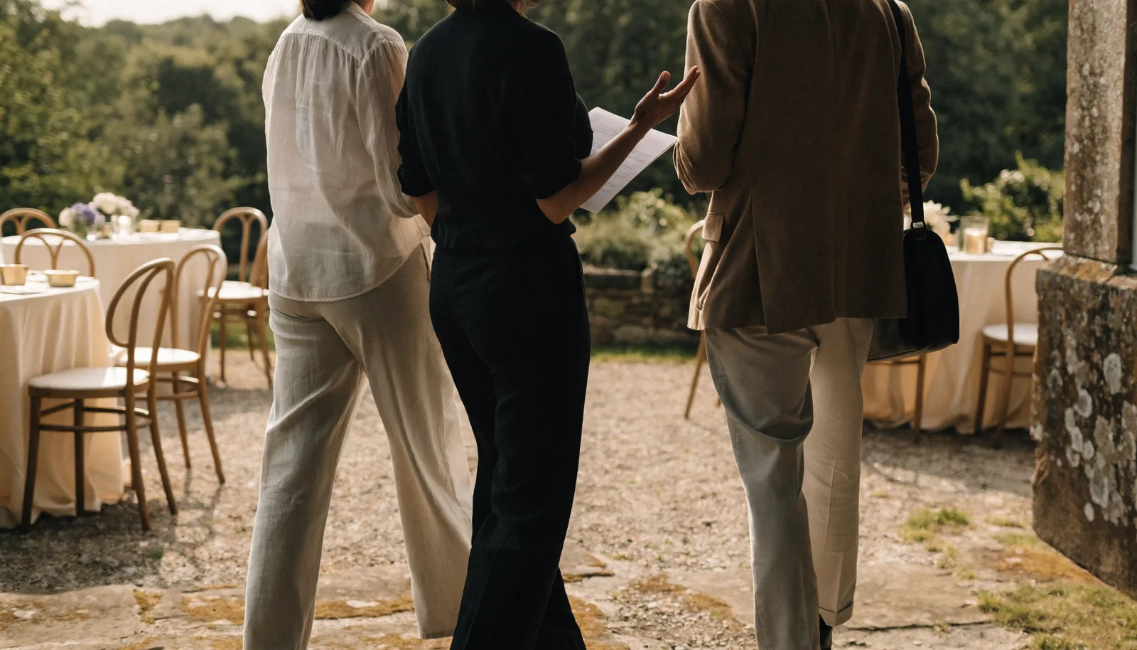 A couple and coordinator walking through a light-filled wedding venue
